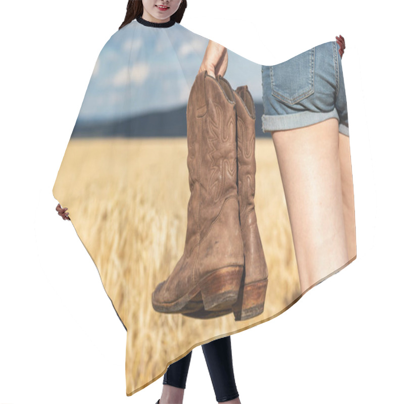 Personality  Woman Holding Cowboy Boots In Field. Cowgirl Walking In Countryside. Worn Leather Riding Boot Hair Cutting Cape