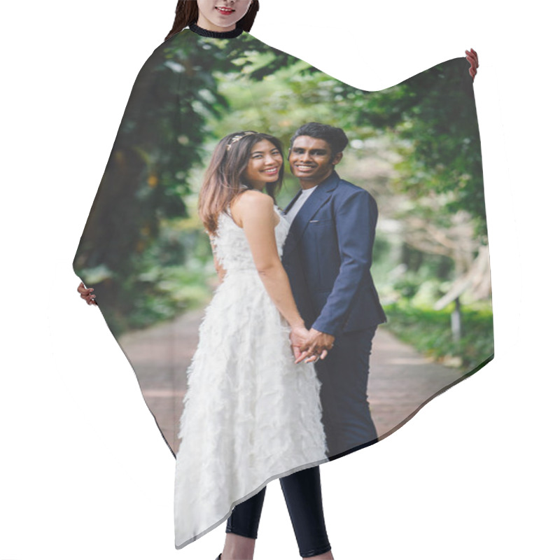 Personality  Portrait Of Interracial Couple Taking Wedding Photos In A Beautiful Park In The Day. An Indian Man And His Chinese Fiance  On A Pathway. Hair Cutting Cape