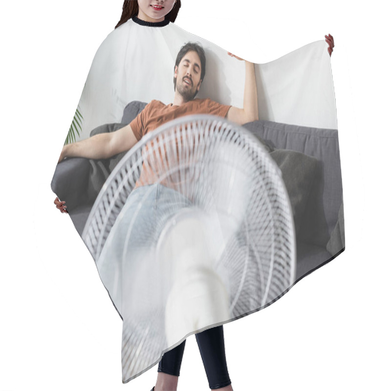 Personality  Pleased Bearded Man Sitting On Couch Near Blurred Electric Fan  Hair Cutting Cape