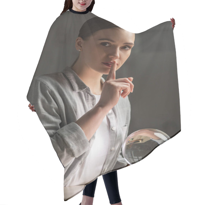 Personality  Attractive Astrologer Showing Silence Gesture And Holding Crystal Ball On Table Hair Cutting Cape