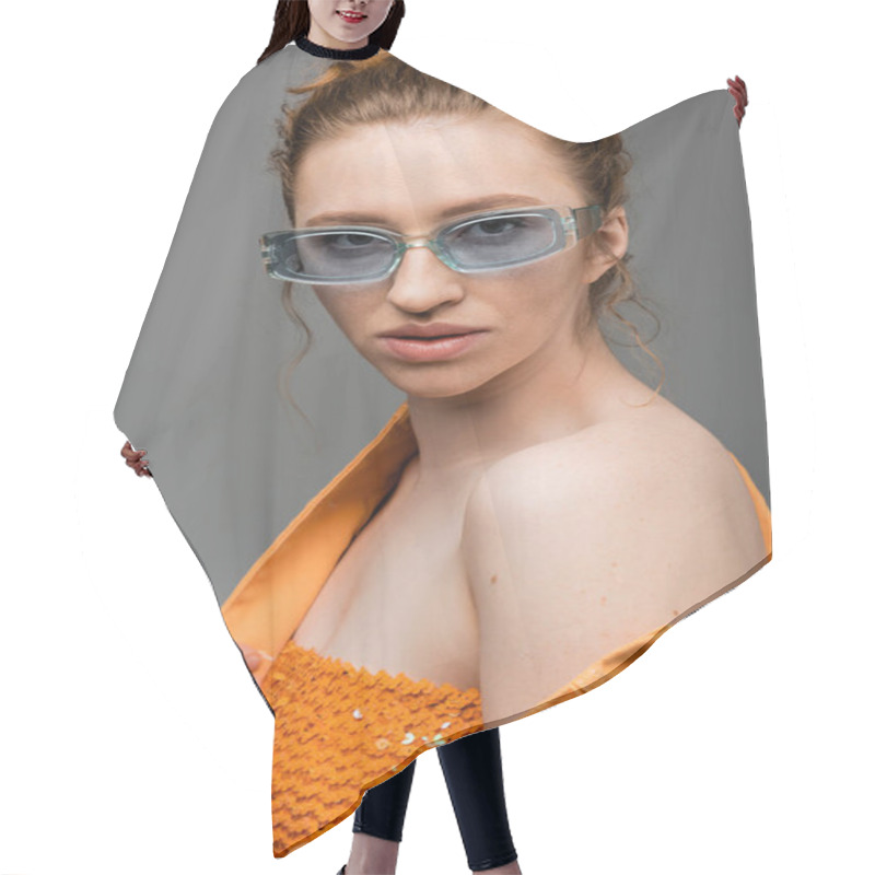 Personality  Confident Young Red Haired Woman In Sunglasses Posing In Top With Sequins And Orange Denim Jacket While Standing Isolated On Grey Background, Trendy Sun Protection Concept, Fashion Model  Hair Cutting Cape