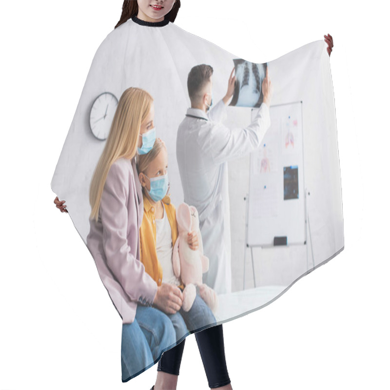 Personality  Woman In Medical Mask Embracing Kid On Medical Couch Near Doctor With Fluorography In Clinic  Hair Cutting Cape