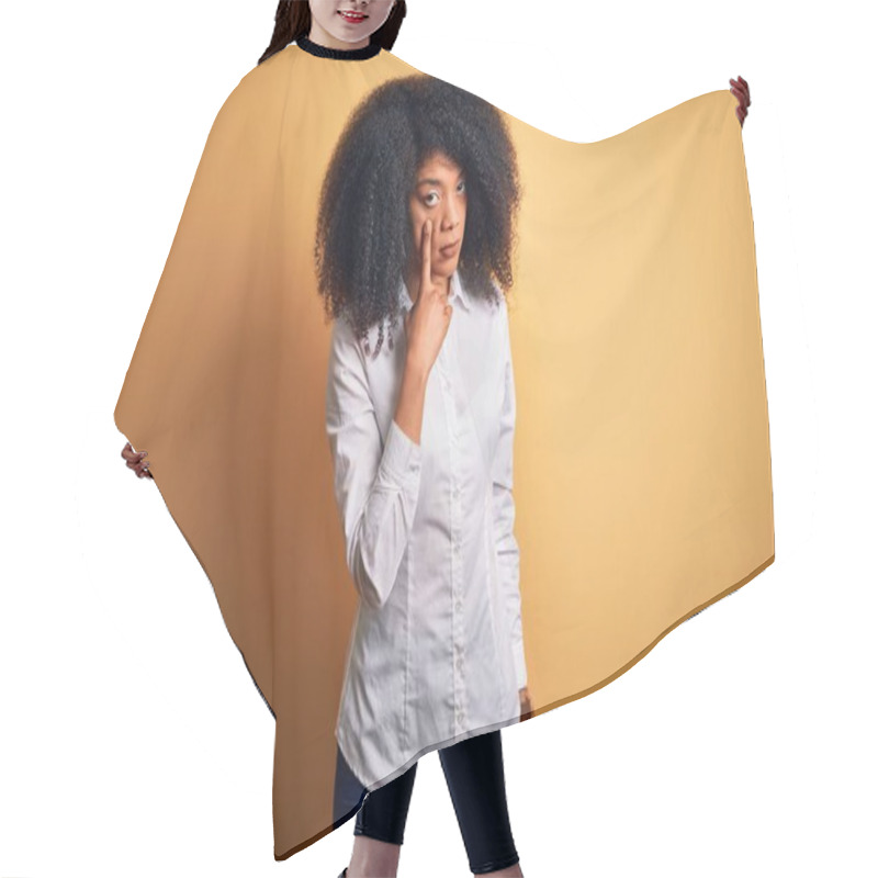 Personality  Young Beautiful African American Elegant Woman With Afro Hair Standing Over Yellow Background Pointing To The Eye Watching You Gesture, Suspicious Expression Hair Cutting Cape