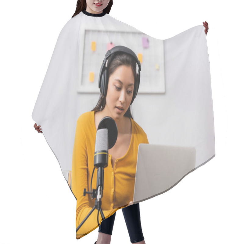 Personality  Concentrated Asian Radio Host In Wireless Headphones Using Laptop Near Microphone In Studio Hair Cutting Cape