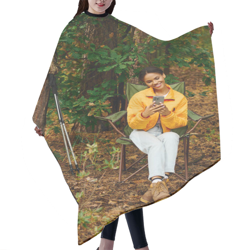 Personality  A Young Woman Sits In A Chair, Smiling At Her Phone Amidst The Colorful Autumn Leaves In The Forest. Hair Cutting Cape