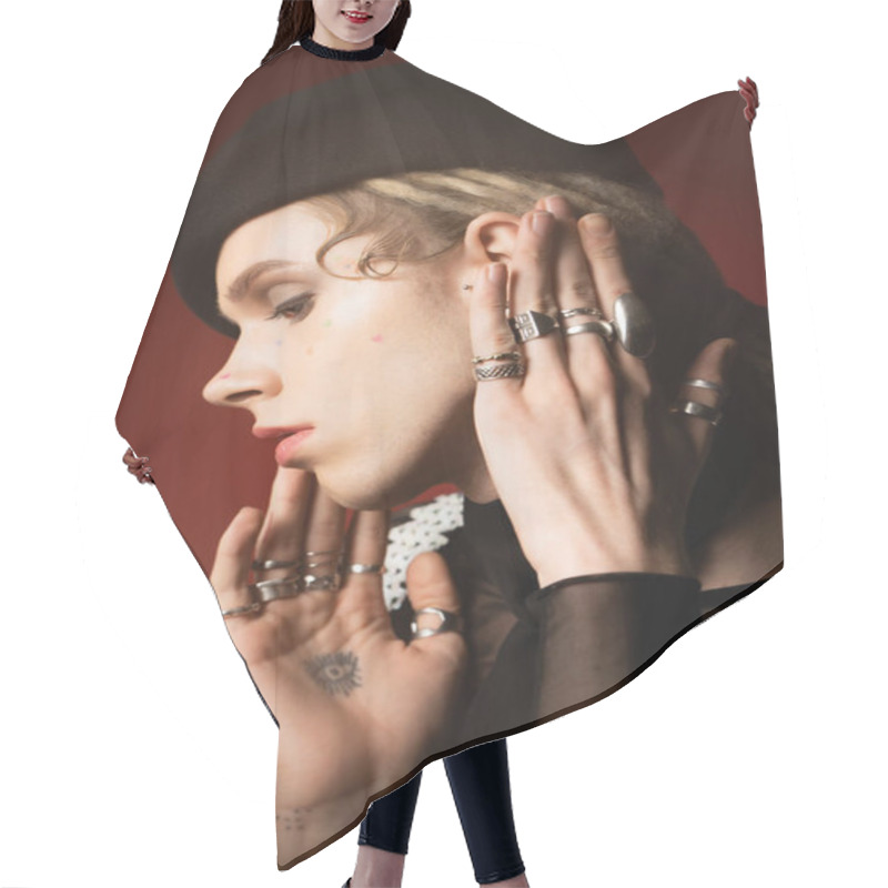 Personality  Portrait Of Tattooed Nonbinary Model In Silver Rings And Black Beret On Dark Red  Hair Cutting Cape