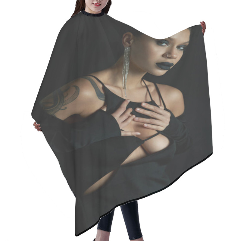 Personality  Gothic Charm, Tattooed Woman In Sexy Halloween Dress Touching Chest And Looking At Camera On Black Hair Cutting Cape