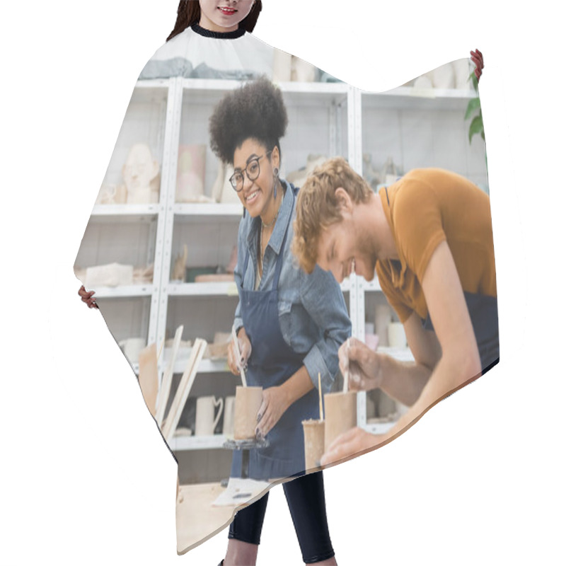 Personality  Smiling African American Woman In Apron Holding Clay Near Boyfriend In Pottery Studio  Hair Cutting Cape