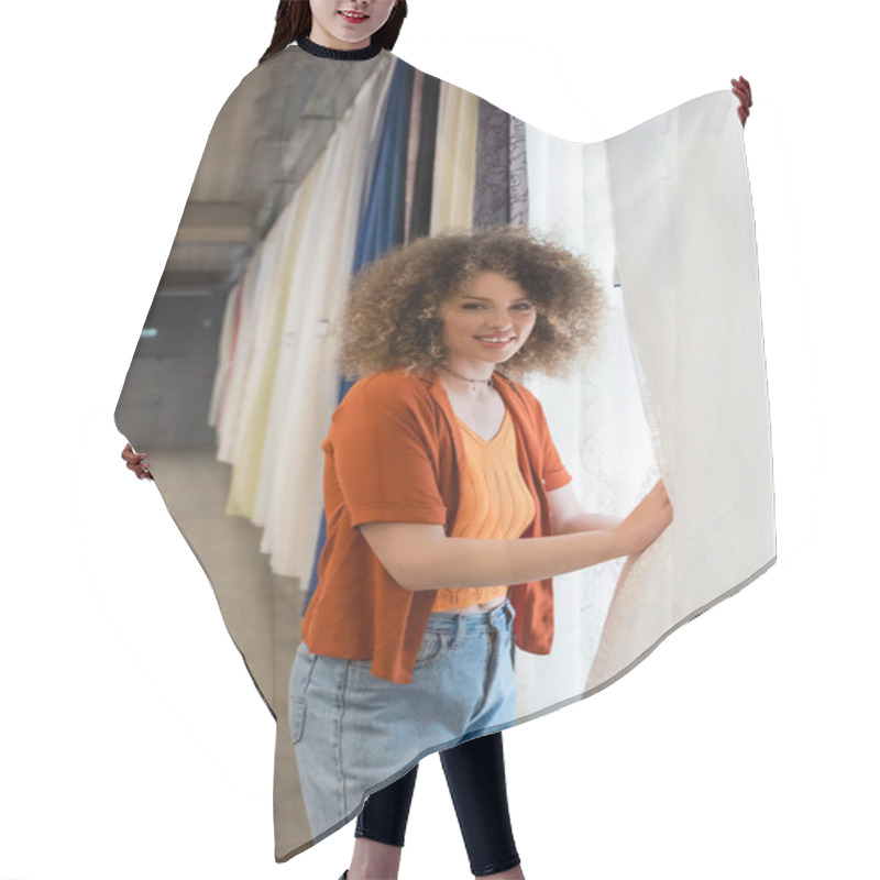 Personality  Curly Woman Smiling At Camera While Choosing Curtains In Textile Shop Hair Cutting Cape