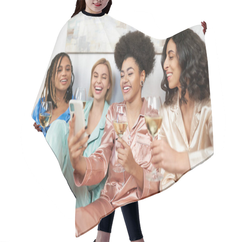 Personality  Cheerful African American Woman Holding Blurred Smartphone Near Multiethnic Girlfriends In Colorful Pajamas Holding Glasses Of Wine During Girls Night At Home, Bonding Time, Slumber Party Hair Cutting Cape