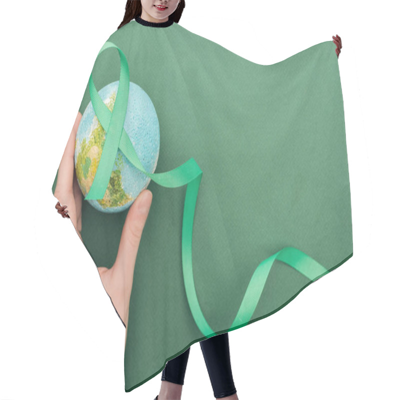 Personality  Cropped View Of Woman Holding Toy Earth And Ribbon On Green Background  Hair Cutting Cape