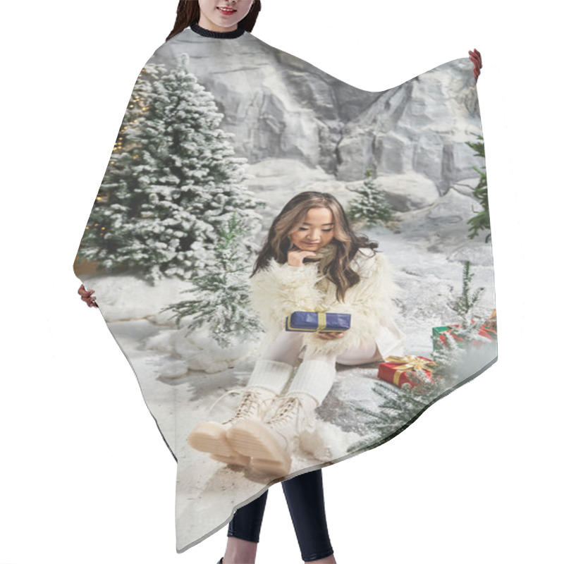 Personality  A Woman In Winter Clothes Happily Looks At A Wrapped Gift In A Snowy Holiday Scene. Hair Cutting Cape