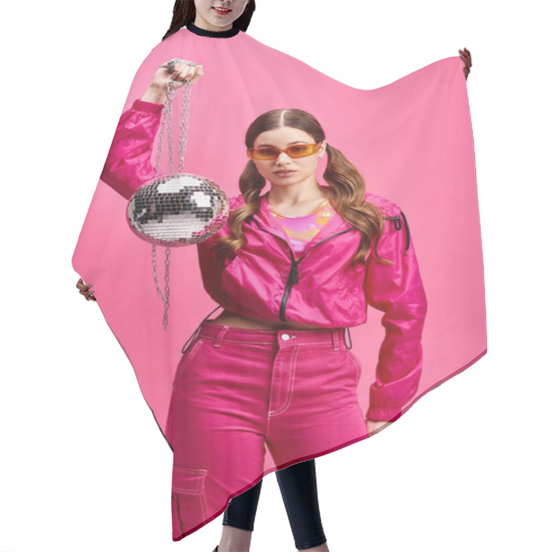 Personality  Young Woman In Her 20s, Stylish In Pink, Holds A Disco Ball In A Vibrant Studio With A Pink Background. Hair Cutting Cape