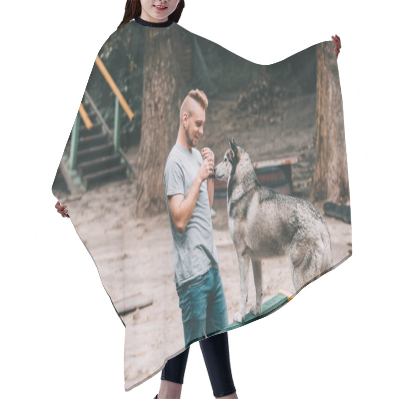 Personality  Young Dog Trainer With Obedient Husky On Dog Walk Obstacle  Hair Cutting Cape