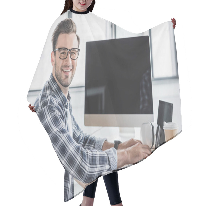 Personality  Handsome Young Programmer In Eyeglasses Smiling At Camera While Working With Laptop And Desktop Computer Hair Cutting Cape