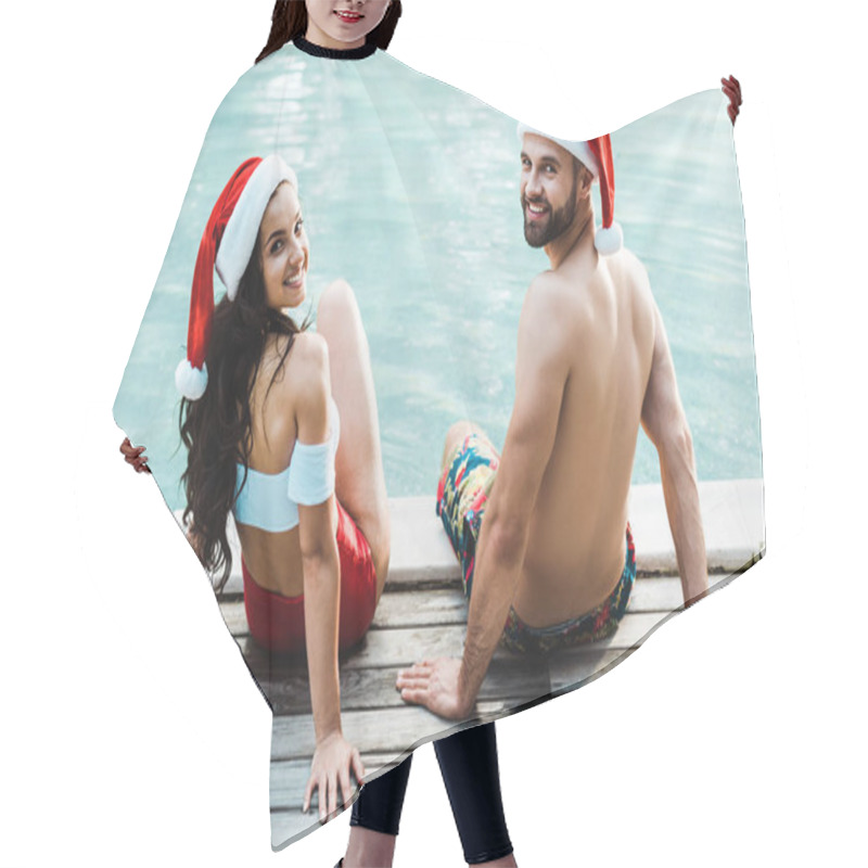 Personality  Cheerful Man And Woman In Santa Claus Hats Sitting On Wooden Decks Near Swimming Pool  Hair Cutting Cape