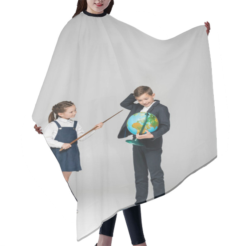 Personality  Smiling Schoolgirl Holding Pointing Stick Near Confused Boy With Globe On Grey  Hair Cutting Cape