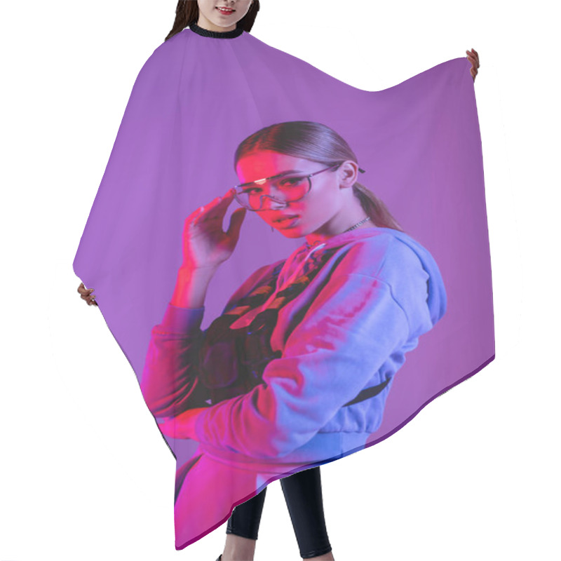 Personality  Young Stylish Woman Adjusting Sunglasses And Posing Isolated On Purple  Hair Cutting Cape