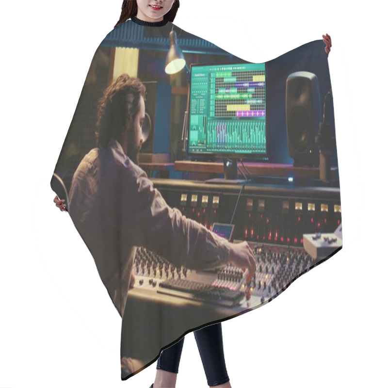 Personality  Music Producer Editing Sounds With Mixing Console And Switchers To Remove Tonal Imbalances Or White Noise, Control Room. Technician Twists Knobs, Adjusting Volume Levels On Recording. Camera B. Hair Cutting Cape