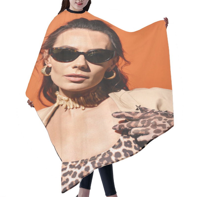 Personality  A Stylish Woman Exudes Confidence In A Leopard Print Top And Trendy Sunglasses Against A Vibrant Orange Background. Hair Cutting Cape