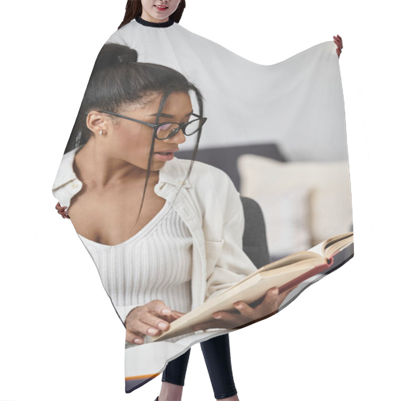 Personality  In A Serene Home Office, A Young Woman Is Intently Reading A Book While Studying Online. Hair Cutting Cape