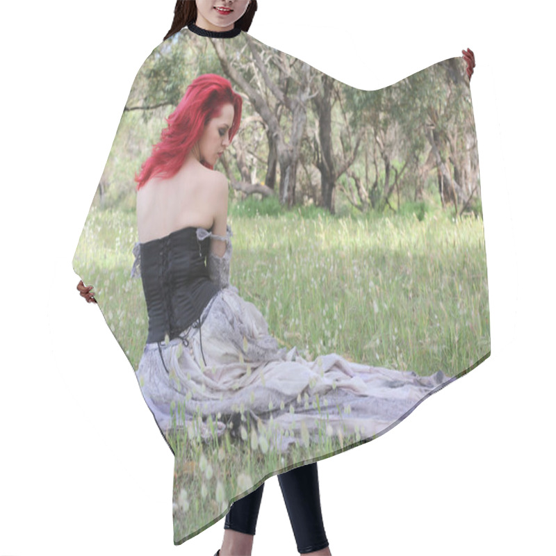 Personality  Full Length Portrait Of Beautiful Red Haired Female Model Figure, Wearing Gothic Fantasy Costume With Torn Ballgown Wedding Dress, Black Corset. Sitting Pose In  Dreamy Flower Field Forest Scenery Background. Hair Cutting Cape