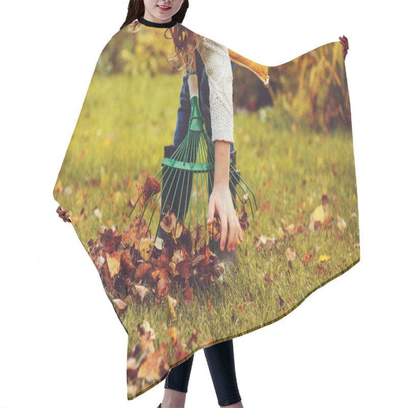 Personality  Happy Child Girl Playing Little Gardener In Autumn And Picking Leaves Into Basket. Seasonal Garden Work. Backyard Cleaning. Hair Cutting Cape