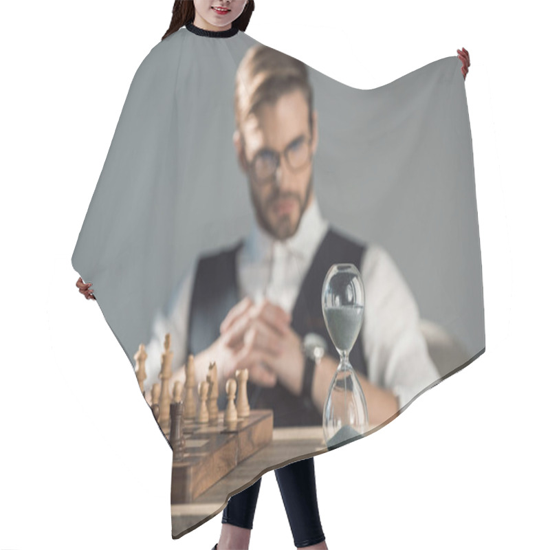 Personality  Close-up View Of Chess Board With Pieces And Sand Clock On Table And Businessman Sitting Behind Hair Cutting Cape