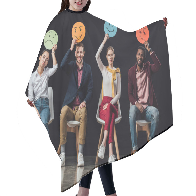 Personality  Multiethnic People Sitting On Chairs And Holding Face Cards With Various Emotions Isolated On Black Hair Cutting Cape