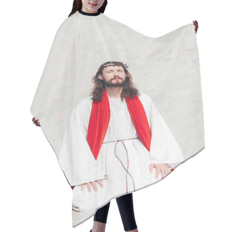 Personality  Jesus In Robe, Red Sash And Crown Of Thorns Standing On Knees With Closed Eyes And Praying In Desert Hair Cutting Cape