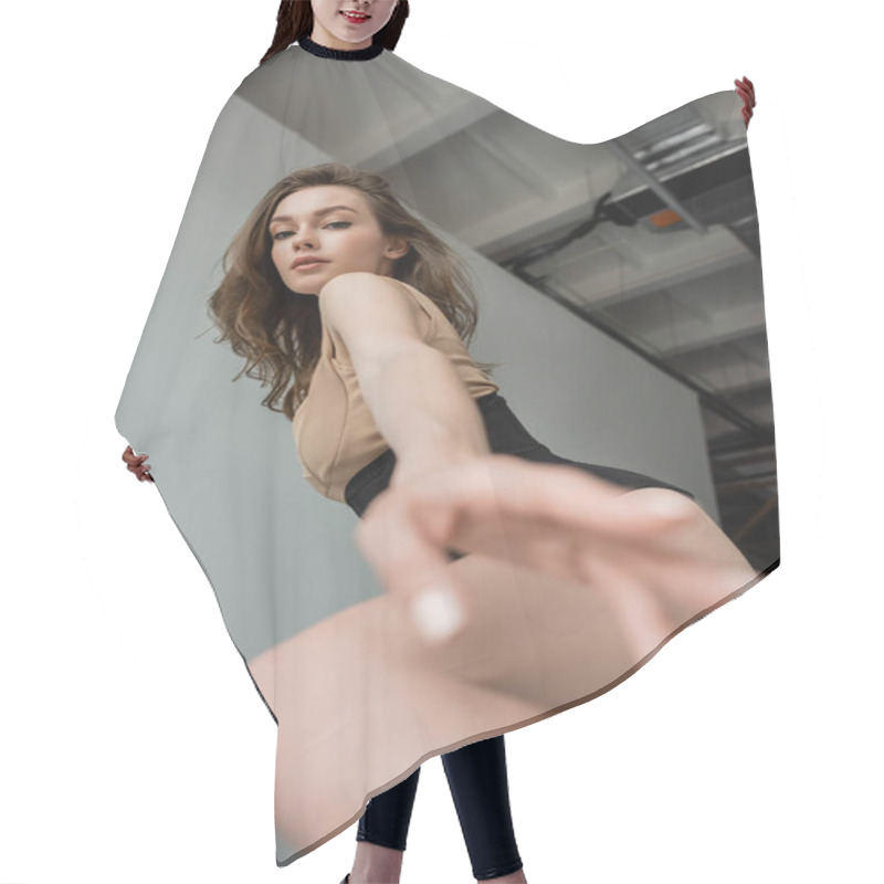 Personality  Low Angle View Of Sensual Young Brunette Woman With Natural Makeup Wearing Bodysuit And Corset While Outstretching Blurred Hand At Camera On Grey Background  Hair Cutting Cape