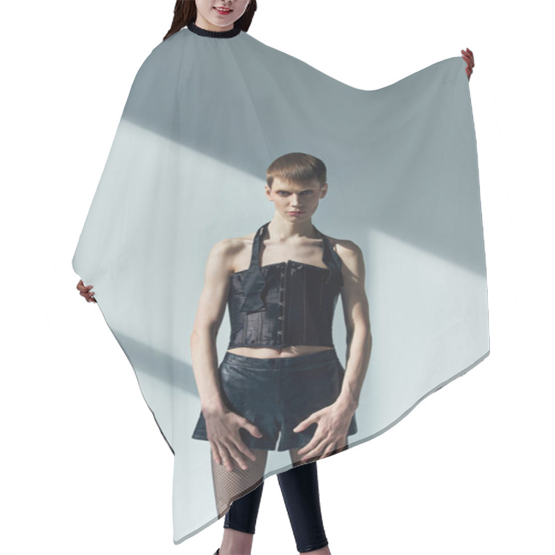 Personality  Androgynous Model In Corset And Shorts Posing On Grey Backdrop With Shadows, Lgbt, Queer Fashion Hair Cutting Cape