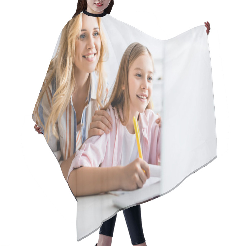 Personality  Selective Focus Of Smiling Woman Embracing Cheerful Daughter During Electronic Learning  Hair Cutting Cape