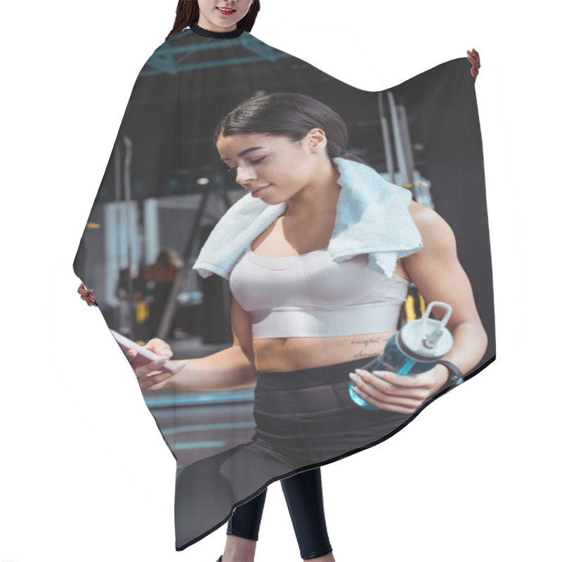 Personality  Beautiful Sportive Girl Using Digital Device While Holding Sport Bottle In Gym  Hair Cutting Cape