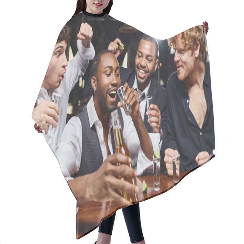 Personality  Happy Interracial Men Cheering Near African American Friend Drinking Tequila Shot And Holding Beer Hair Cutting Cape