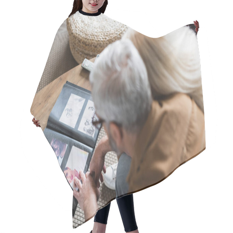 Personality  Overhead View Of Blurred Elderly Couple Sitting Near Photos In Album On Table  Hair Cutting Cape