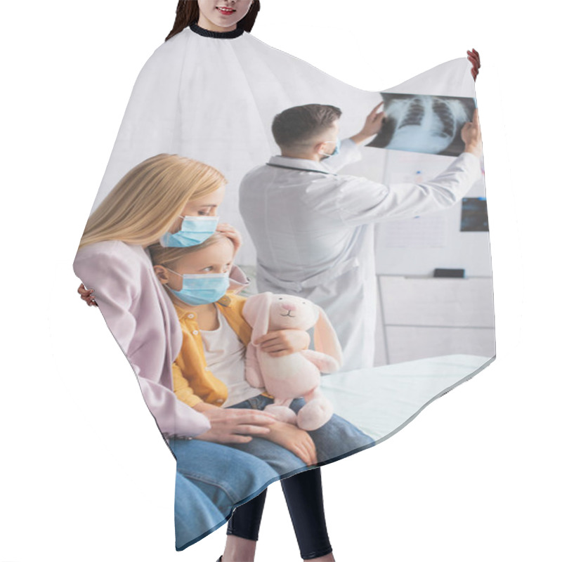 Personality  Woman In Medical Mask Sitting Near Kid On Medical Couch And Blurred Pediatrician With Fluorography Hair Cutting Cape