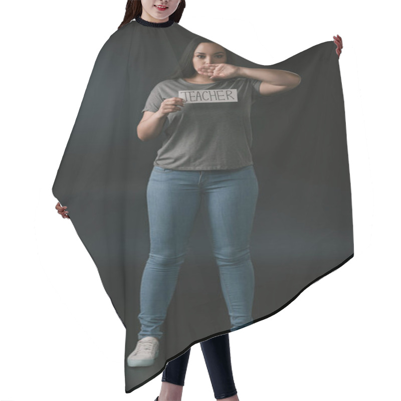 Personality  Full Length View Of Plus Size Girl Holding Card With Word Teacher And Covering Mouth With Hand On Black Background Hair Cutting Cape