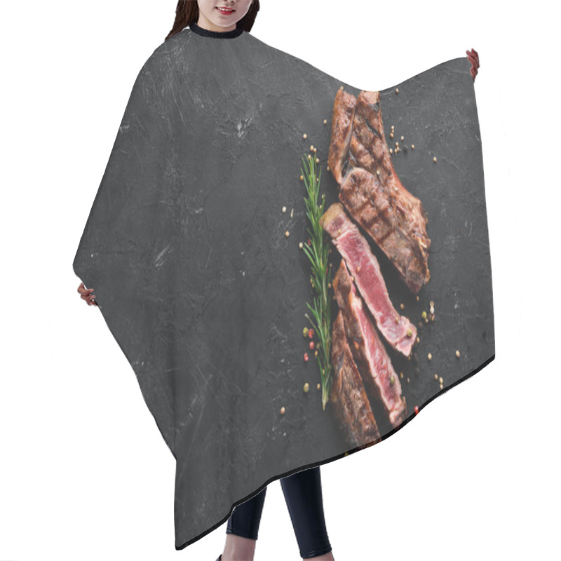 Personality  Veal Steak On A Bone On A Black Background. Free Space For Your Text. Top View. Hair Cutting Cape