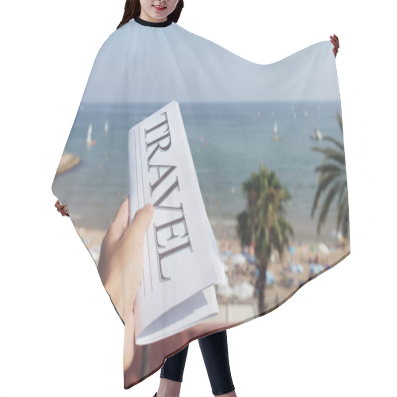 Personality  Cropped View Of Man Holding Newspaper With Travel Lettering On Beach And Blue Sky At Background  Hair Cutting Cape