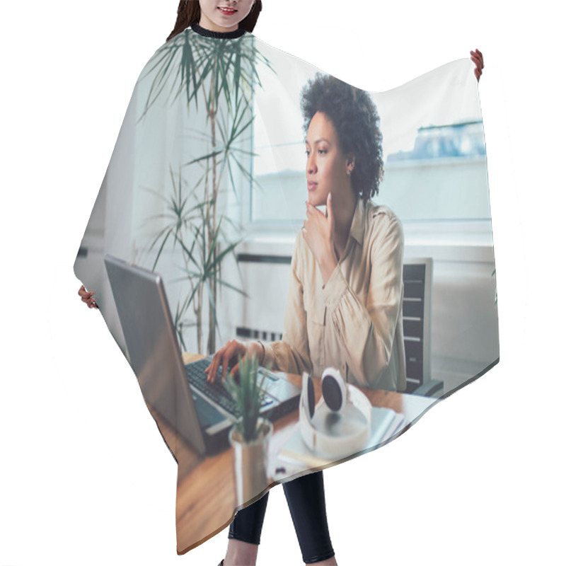 Personality  Smiling Young African Female Entrepreneur Sitting At A Desk In H Hair Cutting Cape