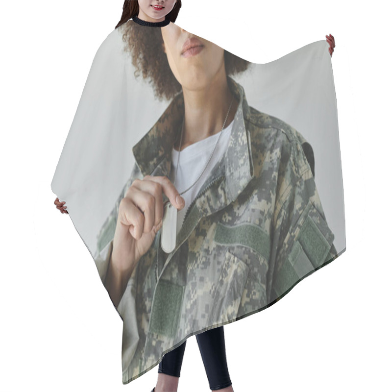 Personality  A Strong Young Woman In Military Camouflage Confidently Holds Her Dog Tags With Pride. Hair Cutting Cape