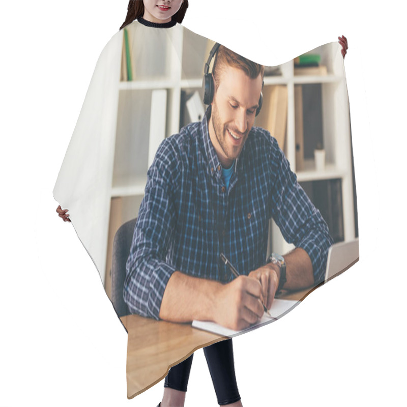 Personality  Portrait Of Smiling Man In Headphones Making Notes While Taking Part In Webinar At Tabletop With Laptop In Office Hair Cutting Cape