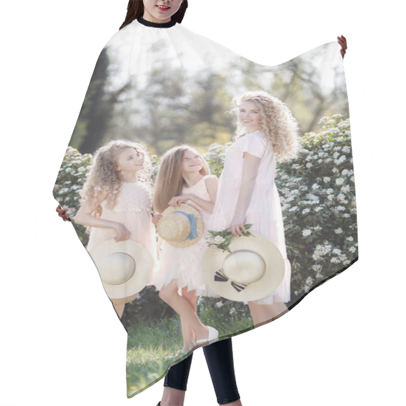 Personality  The Older Sister And Her Two Younger Sisters Spend Time Outdoors In A Beautiful Park With Flowering Shrubs On A Sunny Spring Day. Three Sisters In Pale Pink Dresses With Straw Hats In Their Hands On A Background Of Flowers Hair Cutting Cape