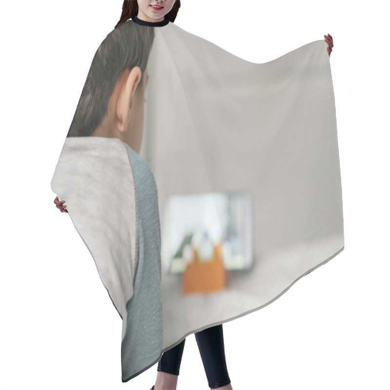 Personality  Back View Of Little Boy Watching Webinar For Children On Smartphone While Lying On Bed Hair Cutting Cape