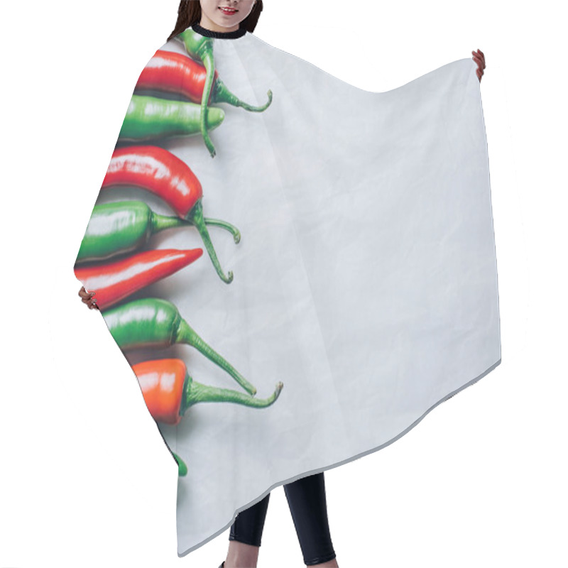 Personality  top view of red and green chili peppers on white tabletop hair cutting cape