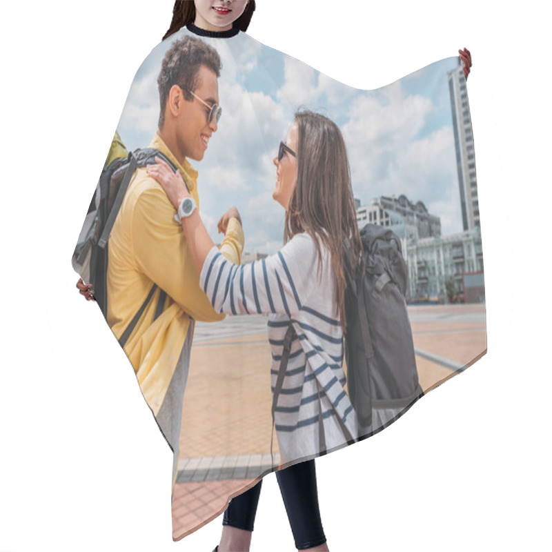 Personality  Side View Of Smiling Woman With Backpack Putting Hand On Shoulder Of Friend Hair Cutting Cape