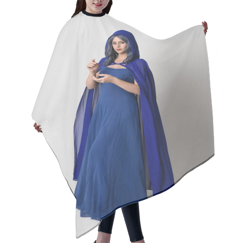 Personality  Full Length Portrait Of Beautiful Female Model Wearing Elegant Fantasy Blue Ball Gown And Flowing Cape With Hood.Standing Pose, With Gestural Arms Reaching Out . Isolated On White Studio Background. Hair Cutting Cape