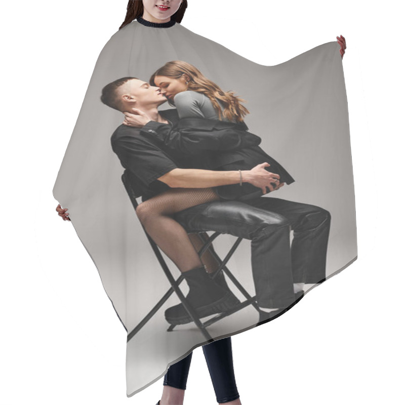 Personality  A Man Sitting On A Chair Passionately Kisses A Woman, Both Wrapped In Love And Intimacy In A Studio Setting With A Grey Background. Hair Cutting Cape