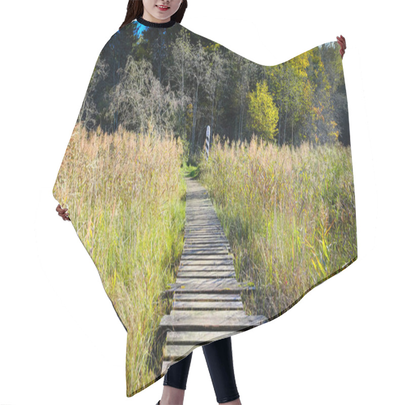 Personality  A Rustic Wooden Boardwalk Leading Through Autumn Wetlands With Tall Reeds And A Border Marker In The Background. Hair Cutting Cape